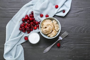 Lezzetli vişneli börek ve koyu ahşap masada sos.