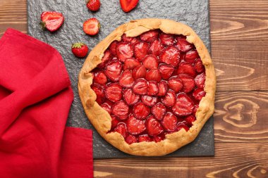 Ahşap zemin üzerinde lezzetli çilekli turta tepsisi