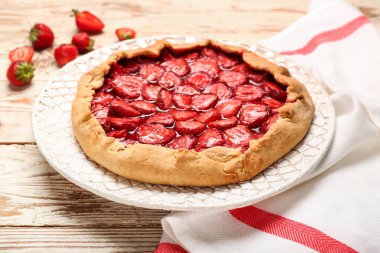 Hafif ahşap zemin üzerinde lezzetli çilekli turta tabağı