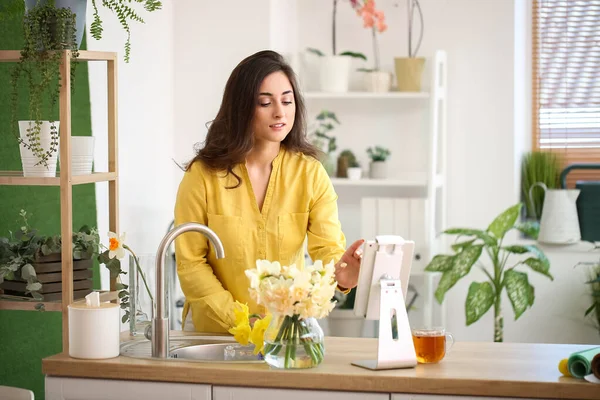 Ung Kvinna Med Bukett Narcissus Blommor Och Surfplatta Dator Hemma — Stockfoto