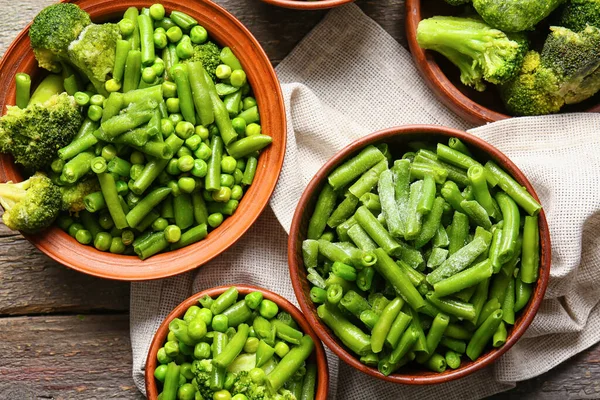 Cuencos Con Verduras Verdes Congeladas Sobre Fondo Madera — Foto de Stock