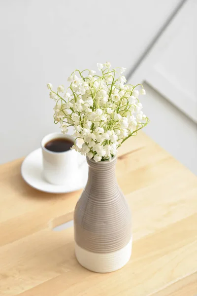 Vaso Com Flores Lírio Vale Xícara Café Mesa Perto Parede — Fotografia de Stock