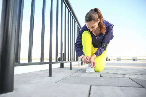 Sporty Young Woman Tying Shoelaces Outdoors — Stock Photo, Image