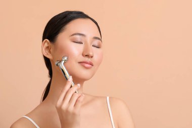 Renkli masaj aleti olan güzel bir genç kadın.