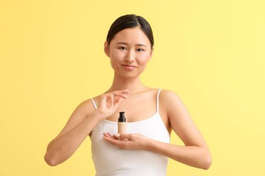 Renkli arka planda makyaj malzemesi olan güzel bir kadın.