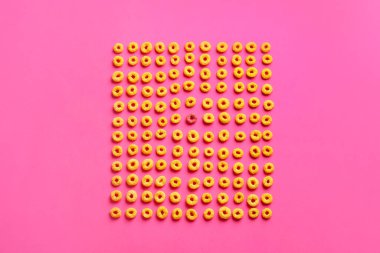 Sarı olanlar arasında pembe mısır gevreği halkası. Eşsizlik kavramı