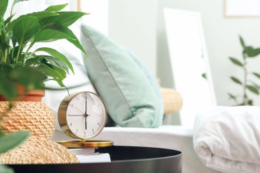 Kaliteli çalar saat ve yatak odasındaki ev bitkisi.