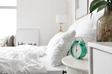 Yatak odasındaki masada şık bir çalar saat.