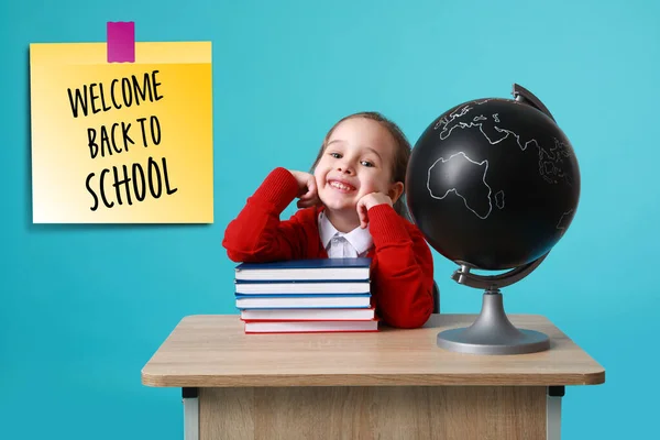 Schattig Klein Schoolmeisje Met Bol Boeken Zitten Aan Het Bureau — Stockfoto