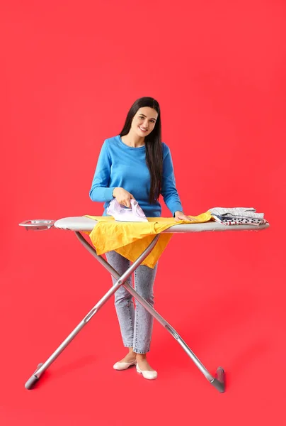 Young Woman Ironing Clothes Color Background — Stock Photo, Image