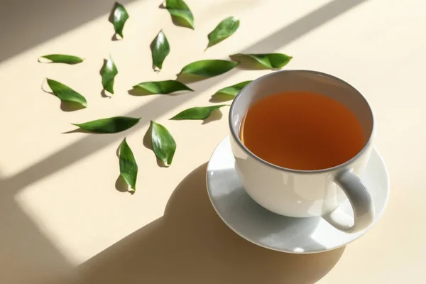 Tasse Tee Und Grüne Blätter Auf Farbigem Hintergrund Nahaufnahme — Stockfoto