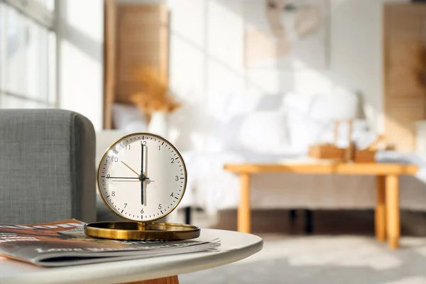 寝室のテーブルの上のスタイリッシュな目覚まし時計と雑誌 — ストック写真