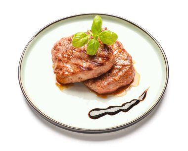 Plate with tasty beef steaks on white background