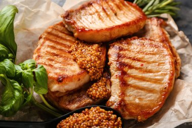 Gri arka planda lezzetli biftekler ve hardal.