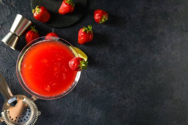 Bir bardak çilekli kokteyl ve koyu arkaplanda böğürtlen.