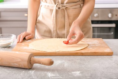 Mutfaktaki masada çilek hazırlayan kadın.