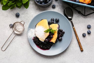 Açık arkaplanda yabanmersinli turta parçaları olan bir tabak.