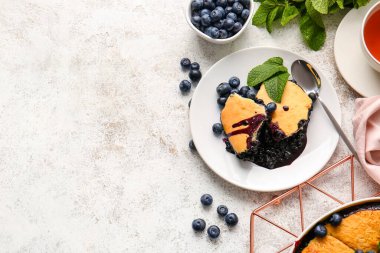 Açık arkaplanda yabanmersinli turta parçaları olan bir tabak.