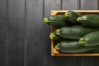 Koyu ahşap arka planda taze kabak kabakları olan ahşap kutu.