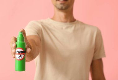 Arka planda sivrisinek kovucu olan genç adam.