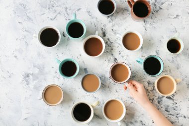 Kadın eli ve arka planda bir fincan kahve.