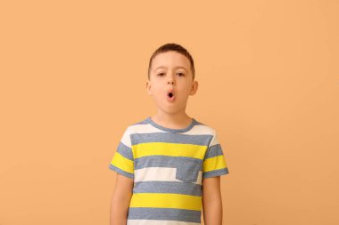 Küçük çocuk renk arka planında harfleri telaffuz ediyor