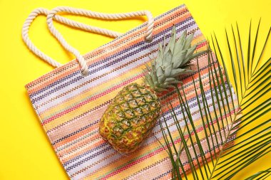 Renkli çanta, palmiye yaprağı ve ananas.