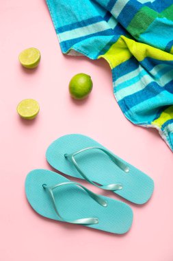 Renkli arka planda havlular, parmak arası terlikler ve limonlar, yakın plan