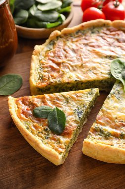 Ahşap arka planda ıspanaklı tart, yakın plan.