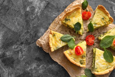 Arkaplanda lezzetli ıspanaklı tart parçaları.