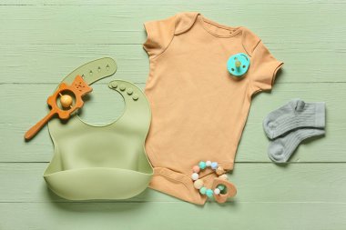 Bebek kıyafetleri, oyuncaklar ve aksesuarlar renkli ahşap arka planda