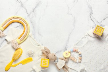 Hafif arka planda bebek kıyafetleri, oyuncaklar ve aksesuarlar