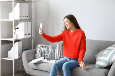 Genç bir kadının evde görüntülü konuşması.