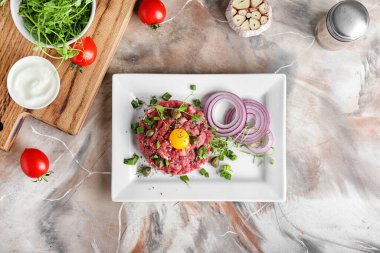 Renkli arkaplanda lezzetli etli tartar tabağı