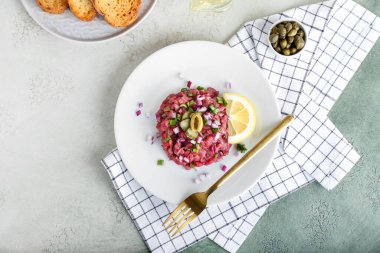 Hafif arka planda lezzetli etli tartar tabağı.