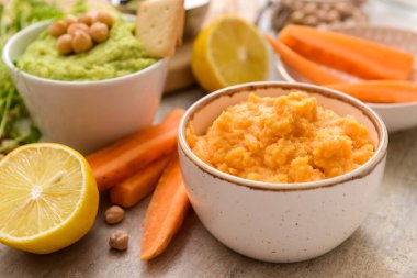 Hafif arka planda lezzetli havuç humusu, limon ve nohut tabakları, yakın plan.