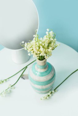 Vadi zambağı çiçekli vazo ve masada ayna.