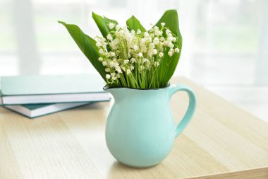 Vadi zambağı çiçekli vazo masada.