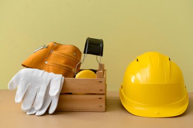 Renk arkaplanında inşaatçı malzemesi olan sert şapka