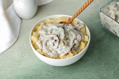 Renkli arkaplanda patates püresi ve mantarlı kase.