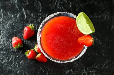 Bir bardak çilekli kokteyl ve koyu arkaplanda böğürtlen.