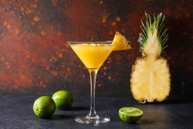 Glass of pineapple daiquiri cocktail on dark background