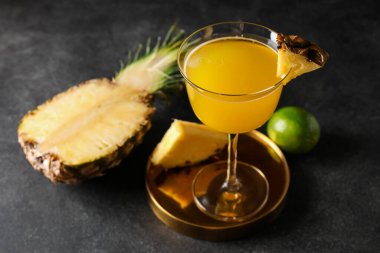 Glass of pineapple daiquiri cocktail on dark background