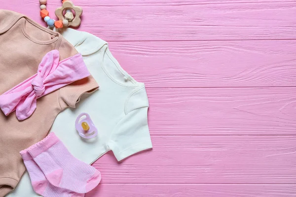 Babybekleidung Und Accessoires Auf Farbigem Holzhintergrund Nahaufnahme — Stockfoto