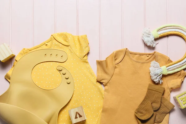 Babybekleidung Lätzchen Und Spielzeug Auf Farbigem Holzhintergrund Nahaufnahme — Stockfoto