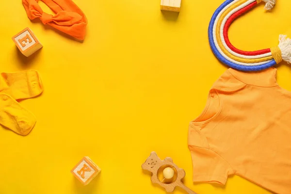 赤ちゃんの服 おもちゃ ヘッドバンドで作られたフレームの色の背景 — ストック写真