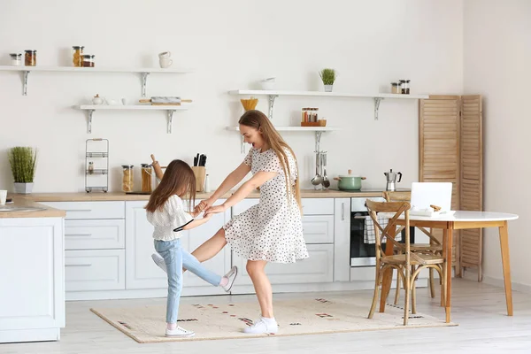 若いです女性と彼女の小さな娘ダンスでキッチン — ストック写真