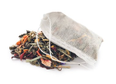 Beyaz arka planda kuru yapraklı çay poşeti