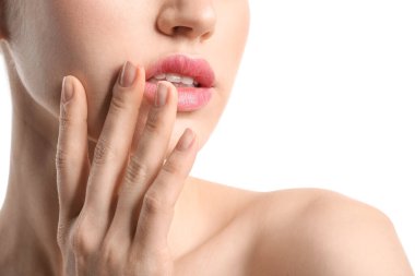 Beyaz arka planda güzel dudakları olan genç bir kadın, yakın plan.