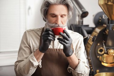 İçeride sıcak kahveyle kıdemli bir adam.